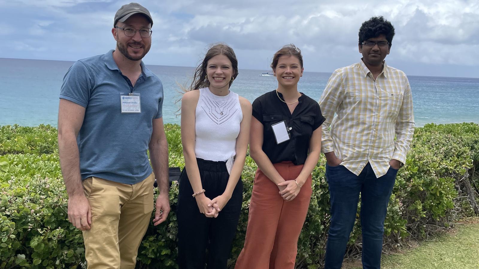Researchers posing in front of the ocean for a group photo