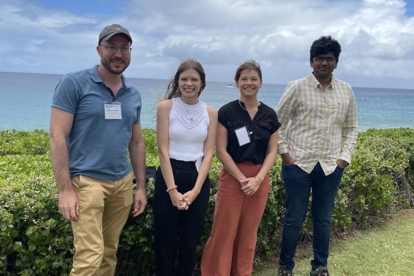 Researchers posing in front of the ocean for a group photo