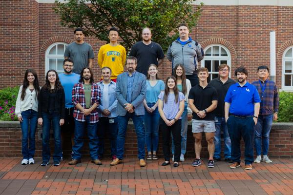 Research team group photo in front of brick building
